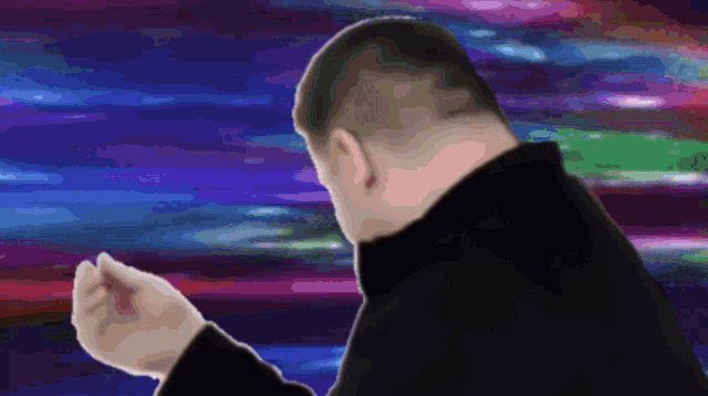 a man in a black sweater is dancing in front of a purple and blue background