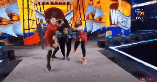 a group of people are dancing on a stage in front of a sony logo