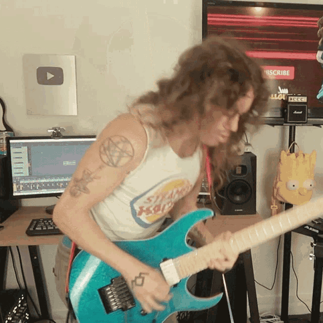 a man is playing a guitar in front of a computer screen that says subscribe
