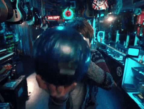 a man is holding a bowling ball in a store .