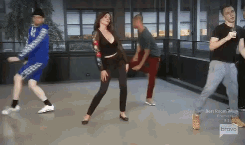 a group of people are dancing in a room with the bravo logo on the bottom
