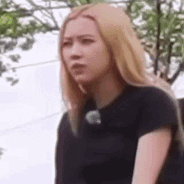 a close up of a woman with blonde hair wearing a black shirt .
