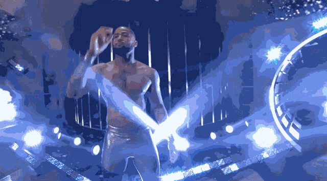 a man without a shirt is holding a light sword in a dark room
