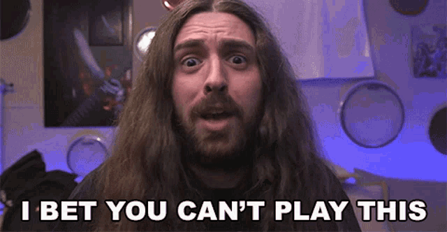 a man with long hair and a beard is saying i bet you can 't play this