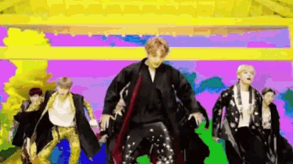 a group of men are dancing on a colorful stage .