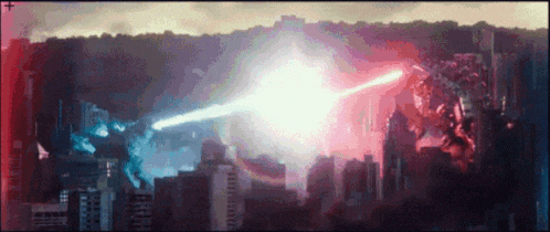 a giant monster is fighting another monster in a city with a red and blue light coming out of it 's mouth .
