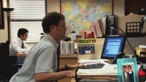 a man sits at a desk in front of a computer with a froggy 101 book on it