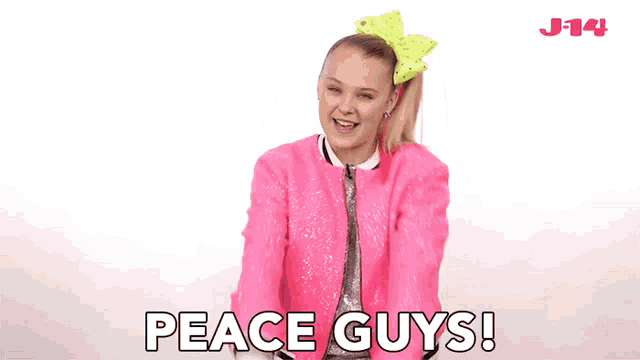 a girl in a pink jacket is giving a peace sign and saying peace guys