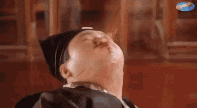 a man with a bloody nose is laying down with his eyes closed and a cigarette in his mouth .