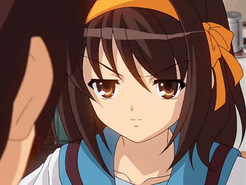 a girl with brown hair and a yellow bow on her head looks angry