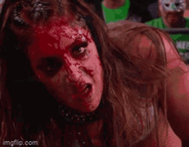 a woman with blood on her face is smiling in a ring