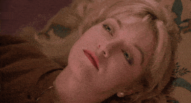 a woman laying down with her eyes closed smiling