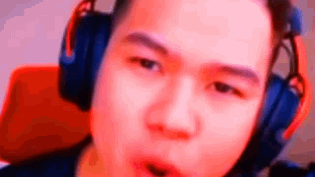 a man is wearing headphones and making a funny face .