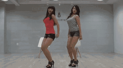 two women are dancing together in a room while wearing high heels .
