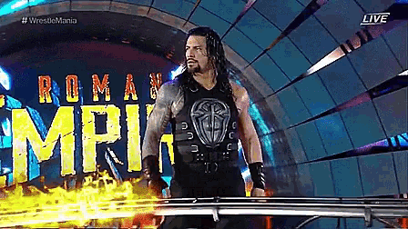 roman reigns is standing in front of a sign that says wrestlemania live