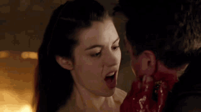 a man and a woman are looking at each other with blood on their faces
