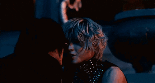 a man and a woman are standing next to each other in a dark room .