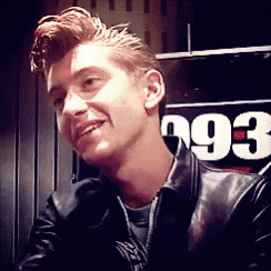 a man in a black leather jacket is smiling in front of a sign that says 993