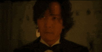 a man in a suit is holding a key in his hand .