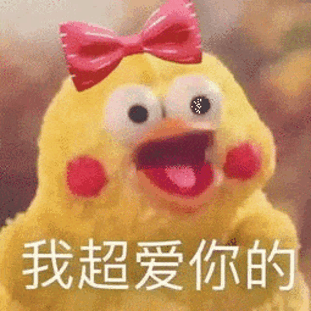 a yellow stuffed animal with a pink bow on its head is making a funny face .