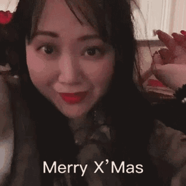 a close up of a woman 's face with the words merry x ' mas written on it .