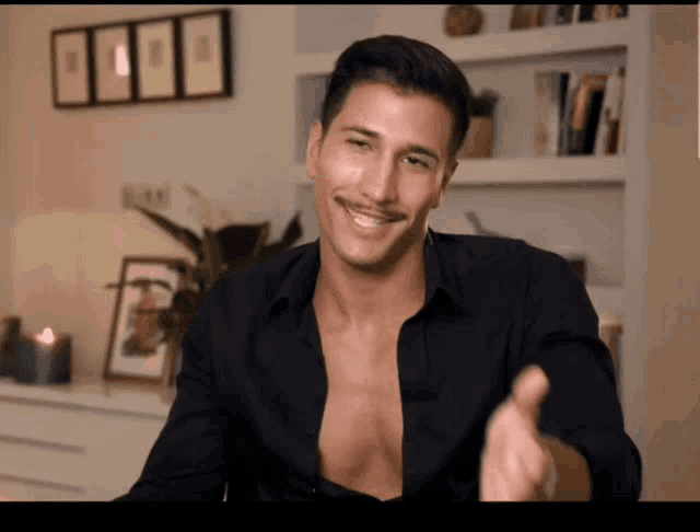 a man in a black shirt without a shirt on smiles