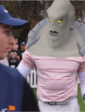 a man wearing a blue hat stands next to a man wearing a pink shirt with a monster on it