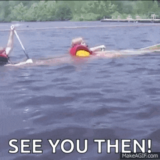 a man in a life jacket is swimming in a lake .