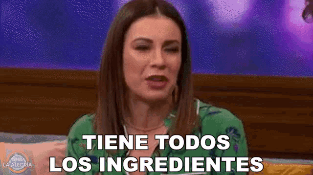 a woman is sitting on a bed and talking in spanish .
