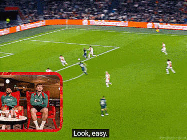 a soccer game is being played in a stadium and a man sitting in a chair says " look easy "