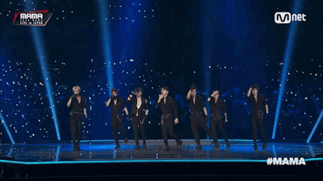 a group of young men are dancing on a stage with the words mama on the bottom