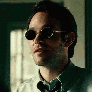 a man wearing sunglasses and a shirt is looking at the camera .