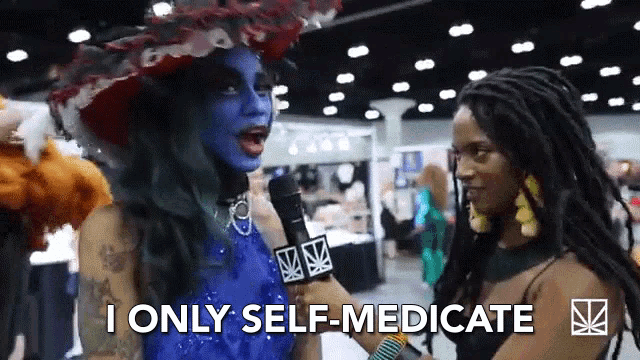 a woman in a blue dress is talking into a microphone and says i only self medicate