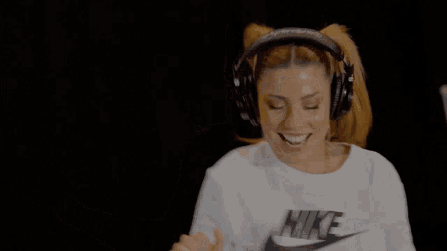 a woman wearing headphones and a white nike t-shirt