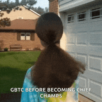 a girl with a ponytail is standing in front of a garage door with gbtc before becoming chief champs
