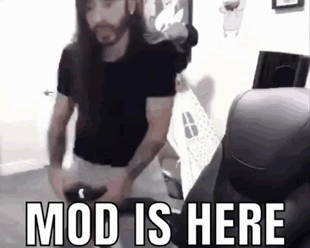 a man with long hair and a beard is playing a video game while holding a controller .