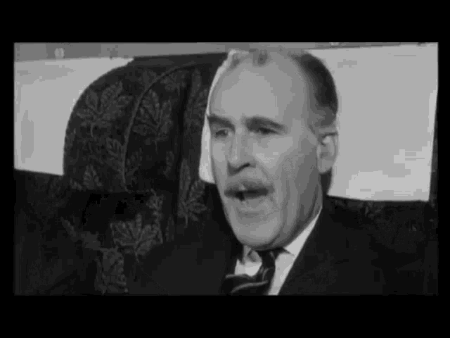 a man in a suit and tie is sitting in a chair with a bandaged head .