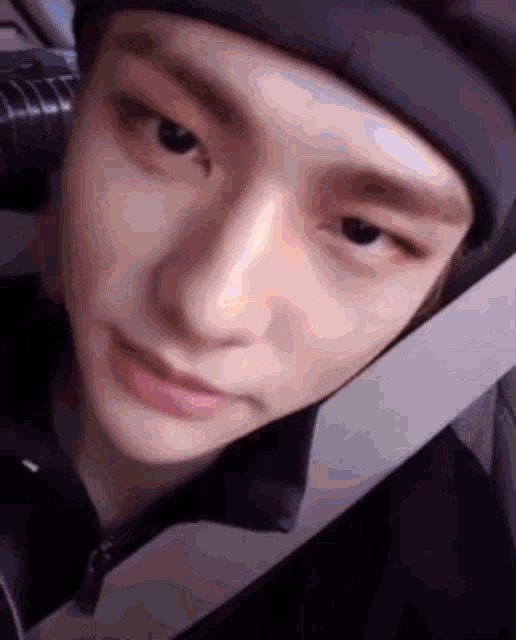 a close up of a person 's face wearing a beanie and a seat belt .