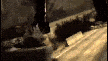 a close up of a person cutting a piece of wood with a saw in a dark room .