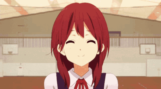 a girl with red hair is smiling with a basketball court in the background