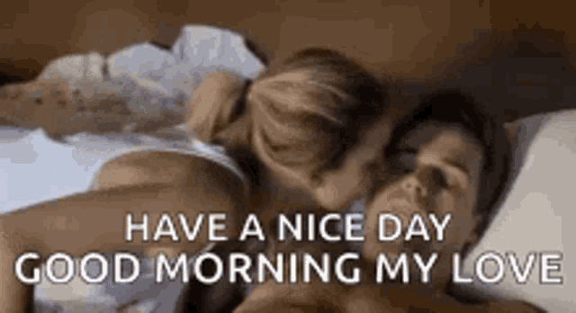 a man and a woman are sleeping on a bed and the man is kissing the woman .