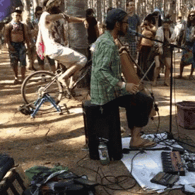a man is playing a musical instrument while a woman sits on a bike
