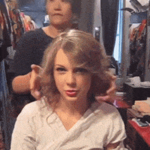 a woman is getting her hair done in a room