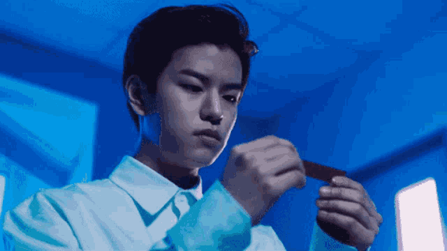 a man in a blue shirt holds a red object in his hands