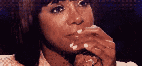 a woman with a ring on her finger is covering her mouth .