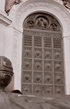 a large door in a building with a statue of jesus on it .