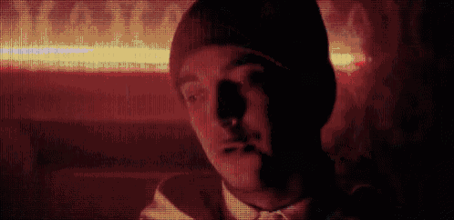 a close up of a man 's face with a beanie on