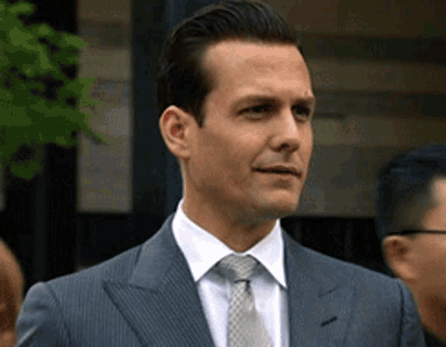 a man in a suit and tie stands in a crowd