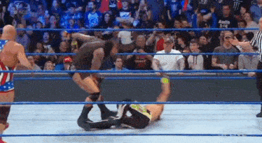 a wrestling match is taking place in a ring with a referee .