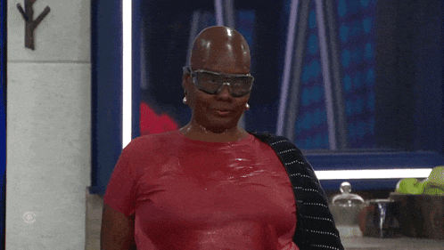 a woman wearing a red shirt and goggles is standing in front of a cbs logo